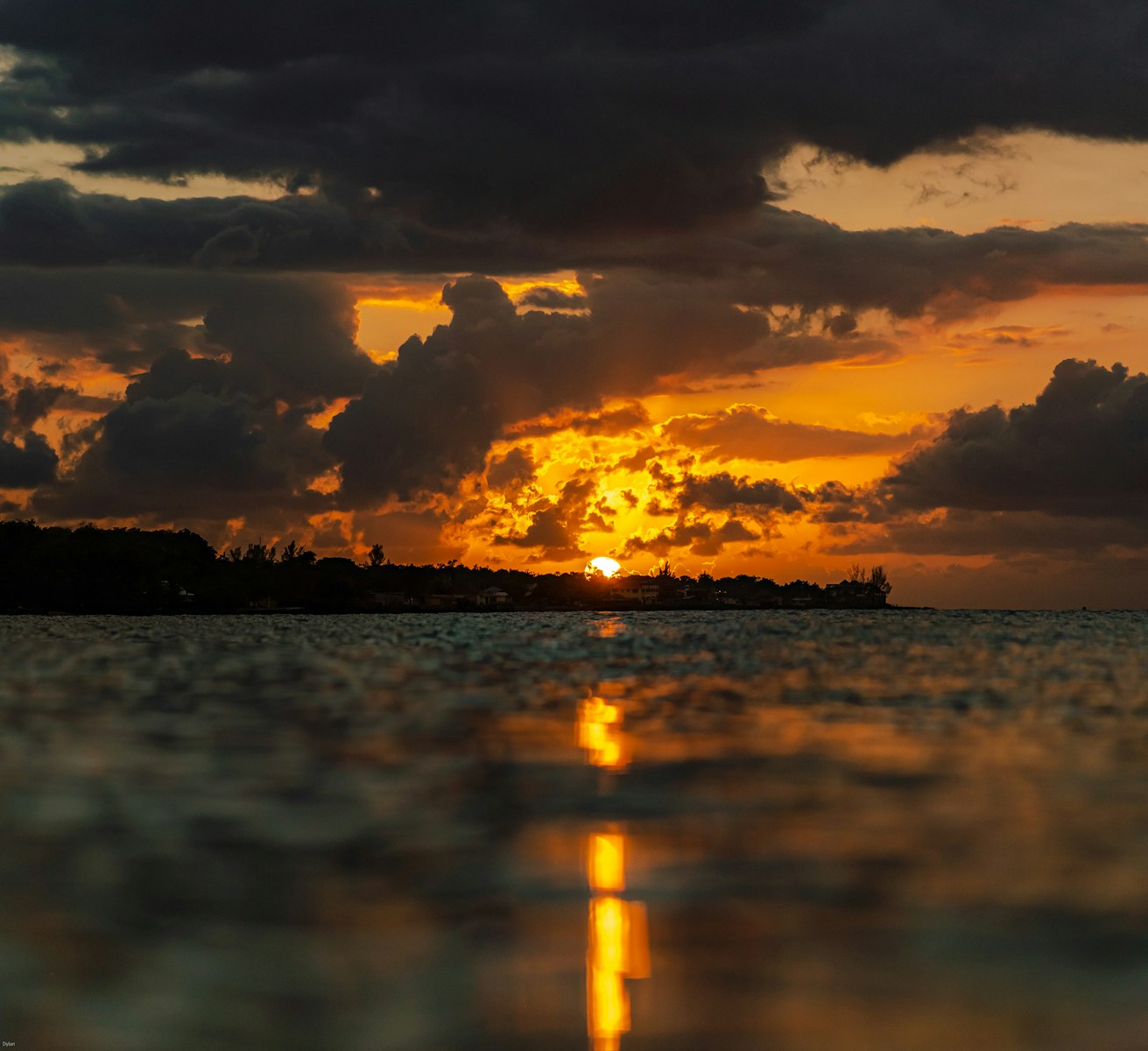 the sun is setting over a body of water