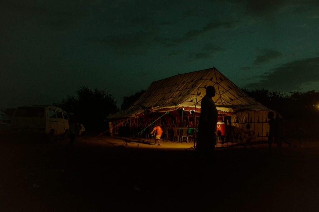 people standing near brown wooden house during night time